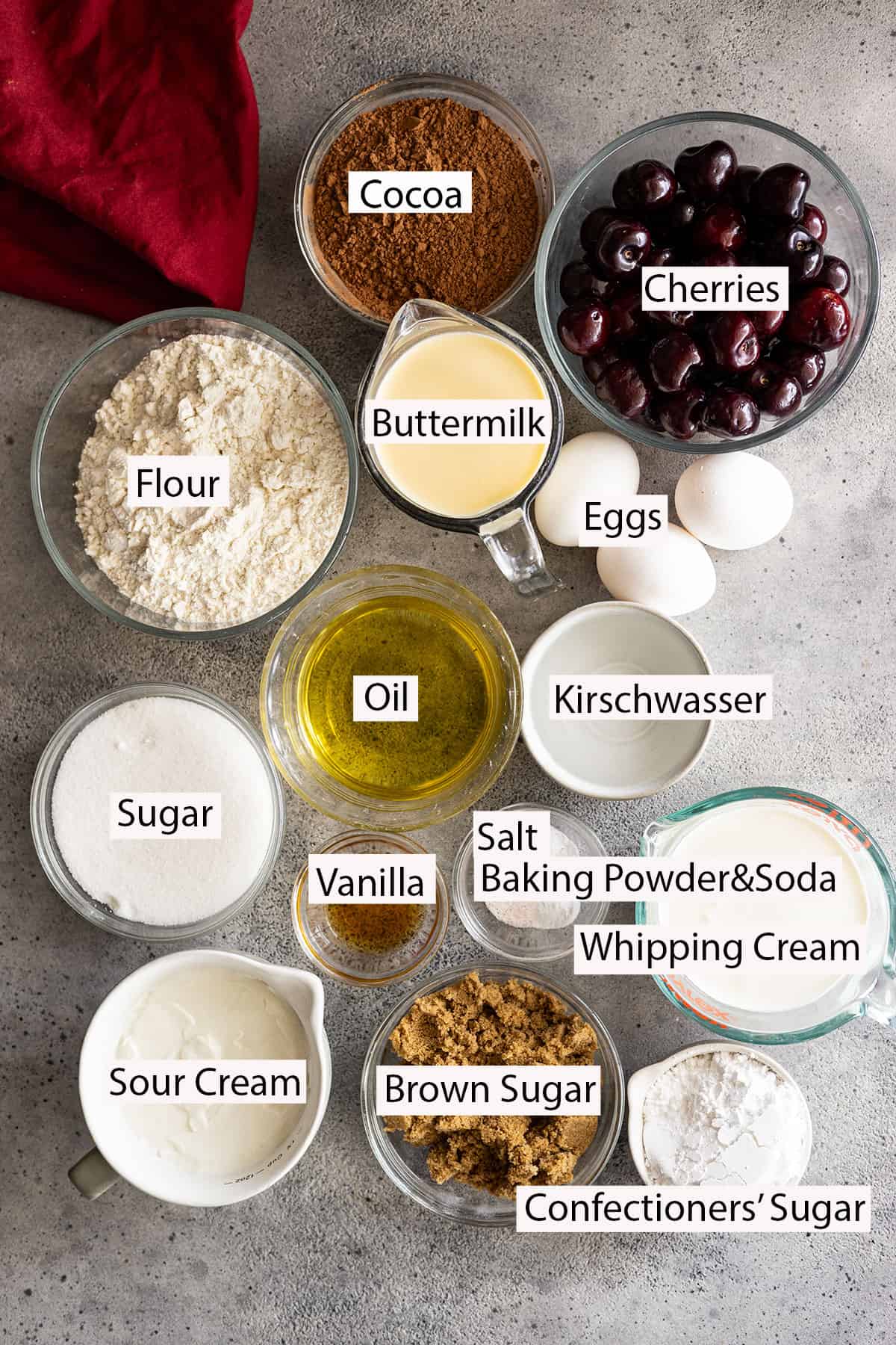 Ingredients: flour, cocoa, cherries, buttermilk, eggs, oil, sugars, vanilla, baking powder and soda, salt, kirschwasser, whipping cream, sour cream, confectioners sugar. 