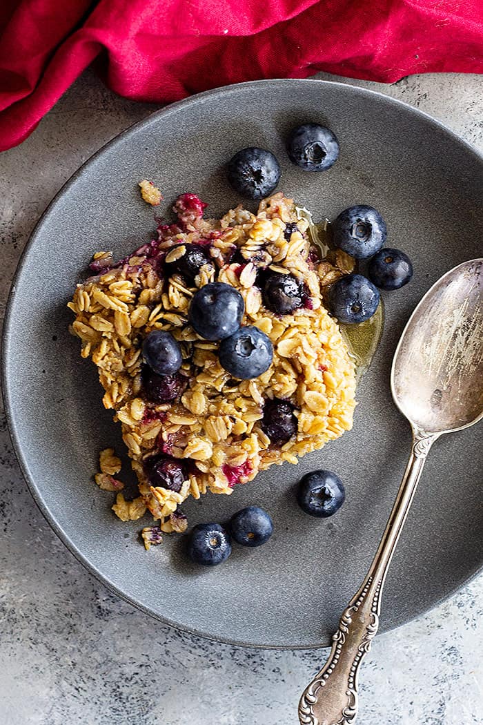 A top down view of baked oatmeal in a bowl topped with fresh blueberries.