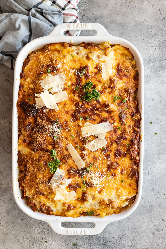 Overhead view of freshly baked ziti from the oven. Garnished with parmesan and parsley.