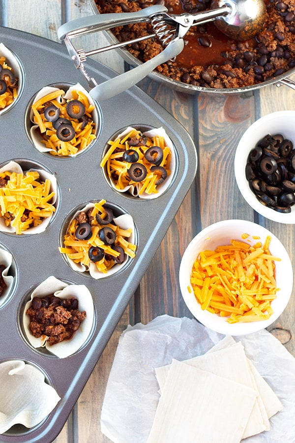 Beef Enchilada Cups- an easy and oh so tasty game day appetizer. Filled with seasoned beef, black beans, cheddar, black olives and topped with creamy sour cream. | Countryside Cravings