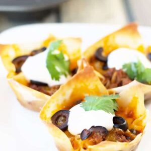 Beef Enchilada Cups- an easy and oh so tasty game day appetizer. Filled with seasoned beef, black beans, cheddar, black olives and topped with creamy sour cream. | Countryside Cravings
