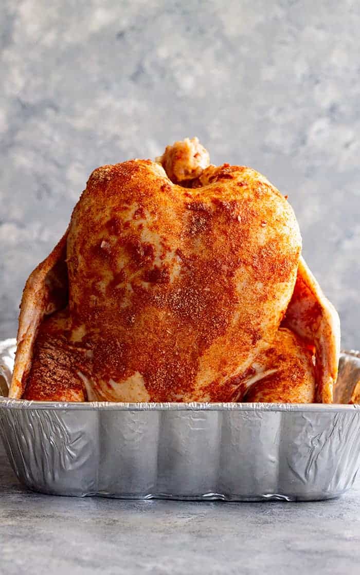 side view: getting beer can chicken in oven ready to bake with rub