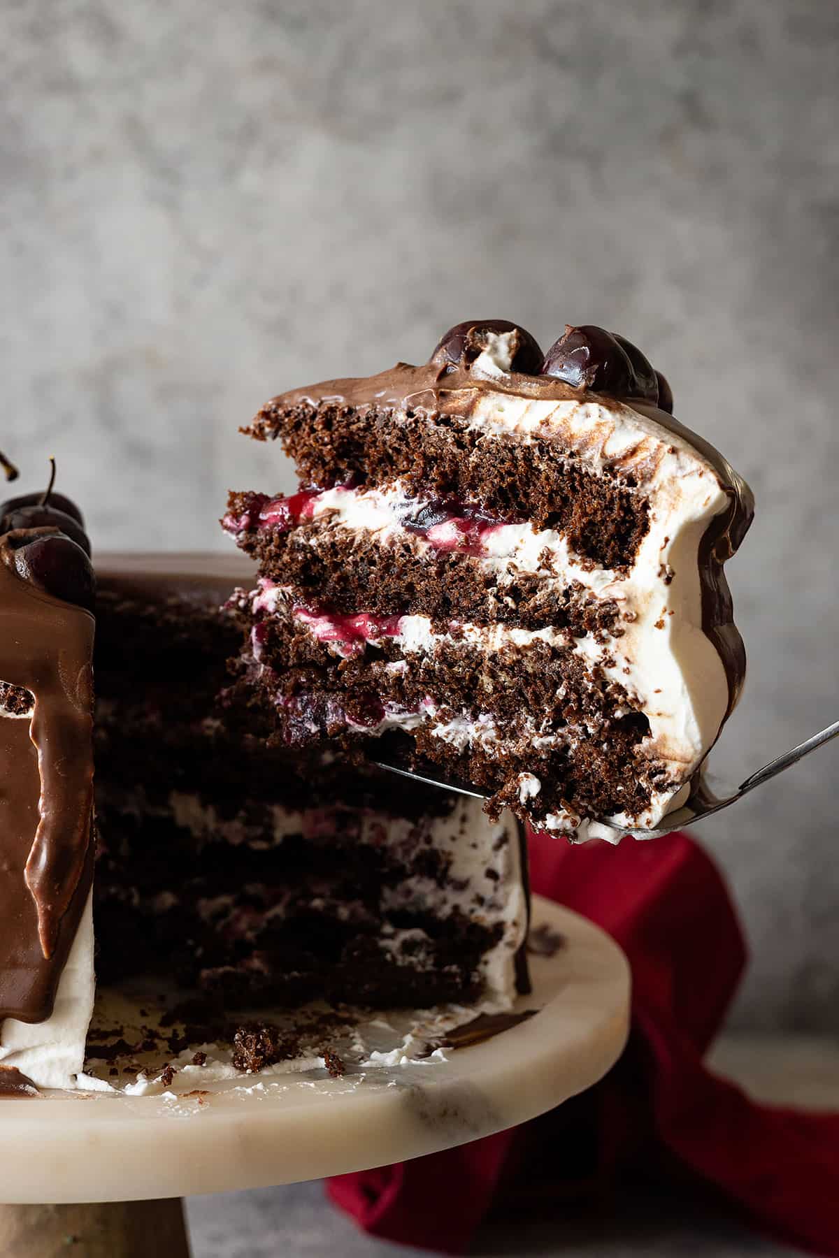 Slice of cake being taken out and ready to put on a plate. 