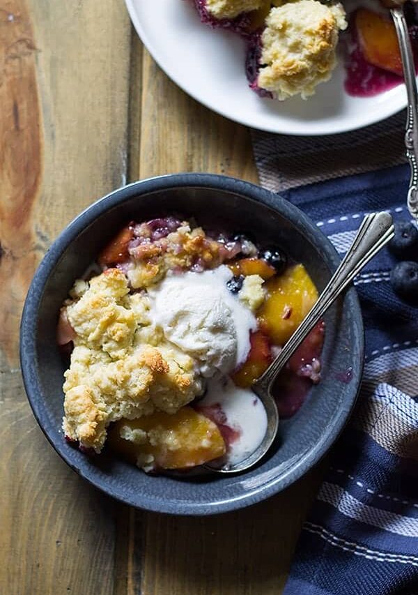 Blueberry Peach Cobbler -an easy recipe made with fresh peaches and blueberries baked beneath a fluffy biscuit topping! | www.countrysidecravings.com