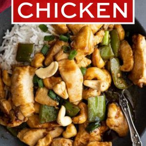 Overhead view of cashew chicken on a plate with white rice to the side.