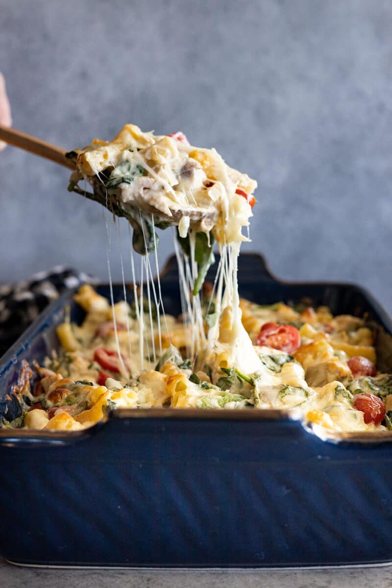 Spoon pulling up the casserole showing a nice cheese pull. 