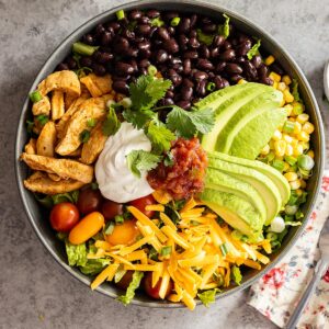 Overhead view of taco bowl with fork and napkin off to the side.