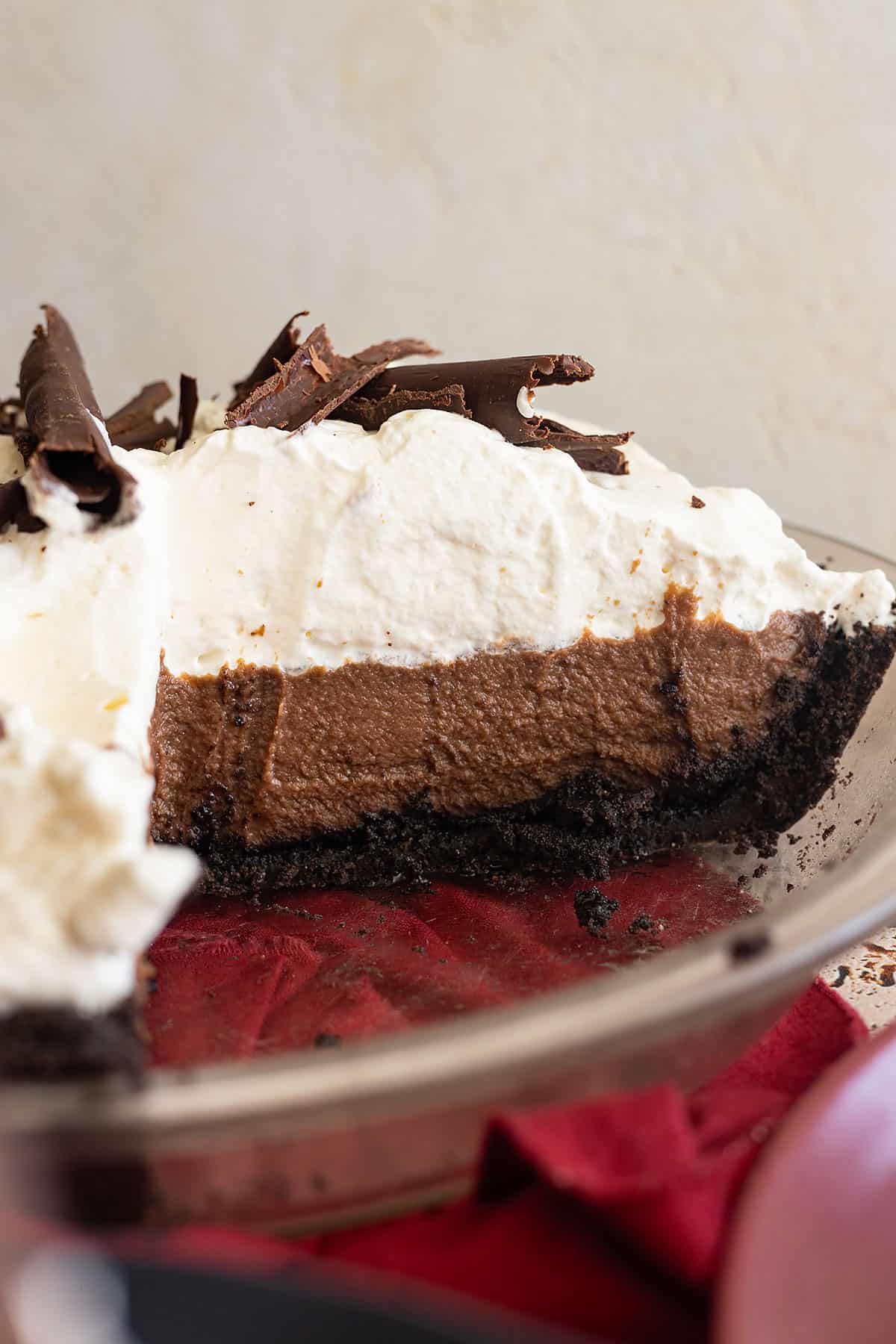 Slice of chocolate cream pie removed from the pie plate. Showing the inside of the rest of the pie in the plate. 
