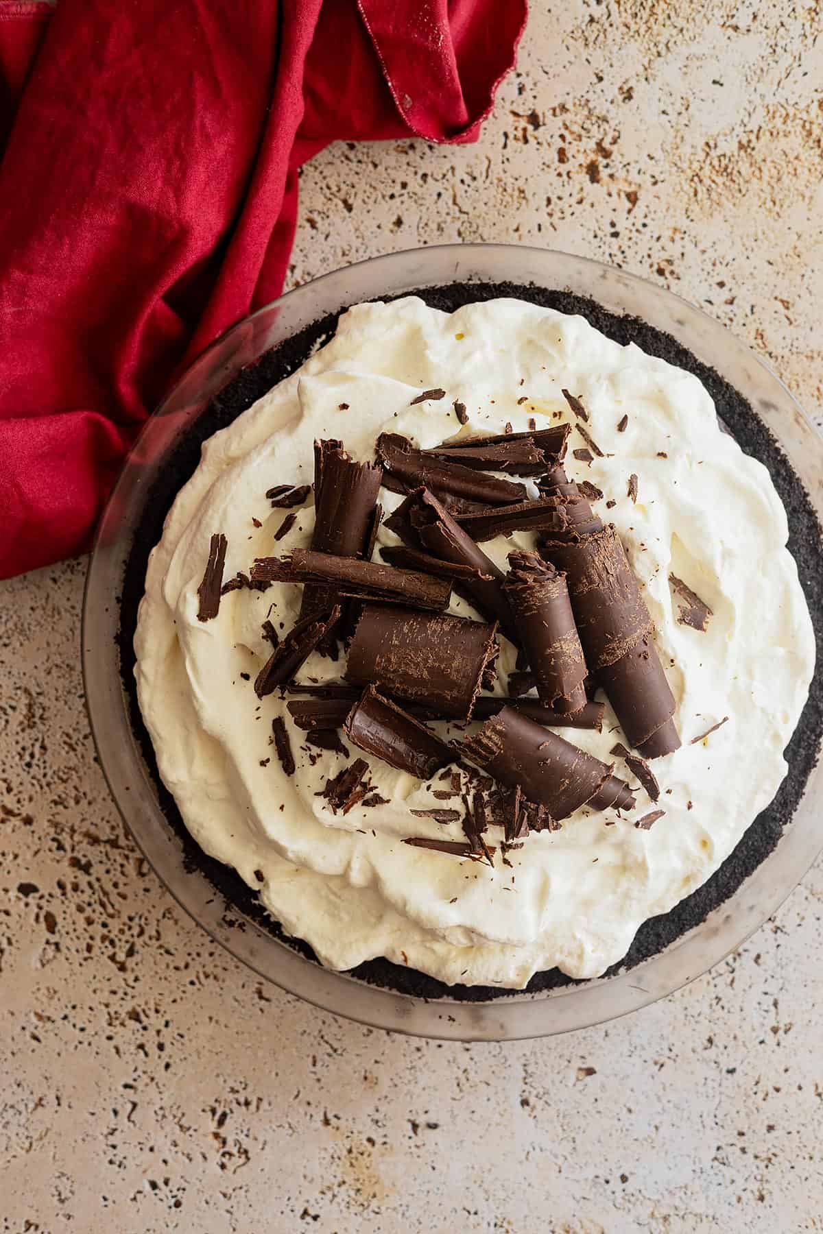Overhead view of pie topped with loads of chocolate curls. Red napkin in the corner. 