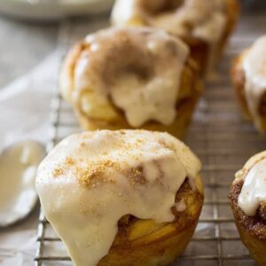These Cinnamon Roll Muffins are a tender homemade yeast roll made in a muffin tin! Topped with a delicious vanilla icing makes these the perfect breakfast! | www.countrysidecravings.com