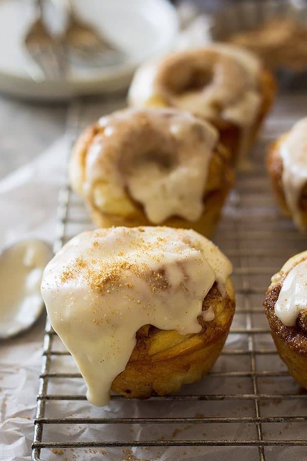 These Cinnamon Roll Muffins are a tender homemade yeast roll made in a muffin tin! Topped with a delicious vanilla icing makes these the perfect breakfast! | www.countrysidecravings.com