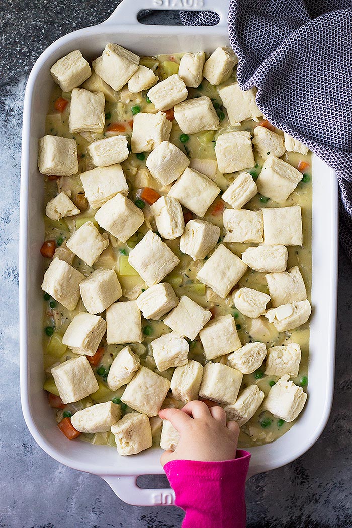 Chicken pot pie with raw biscuits on top before baking. 