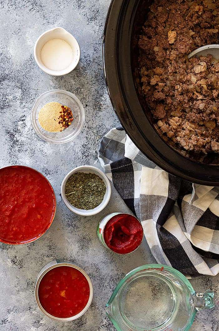 overhead: crockpot spaghetti sauce ingredients ready to add to the slow cooker