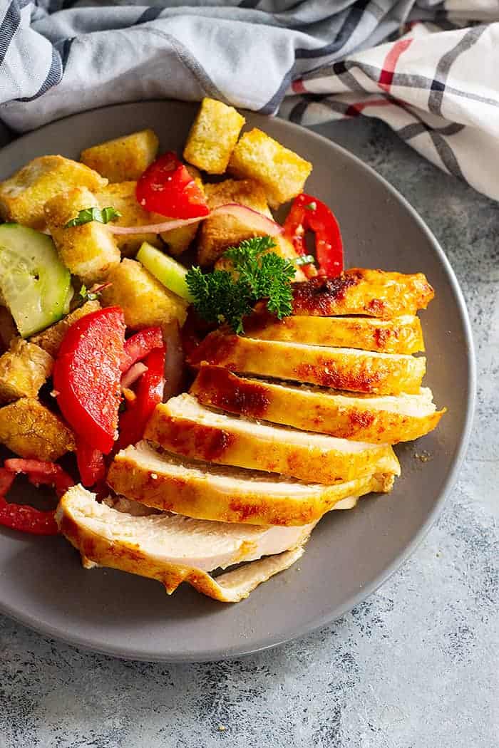 overhead: cut beer butt chicken breast on a plate with salad