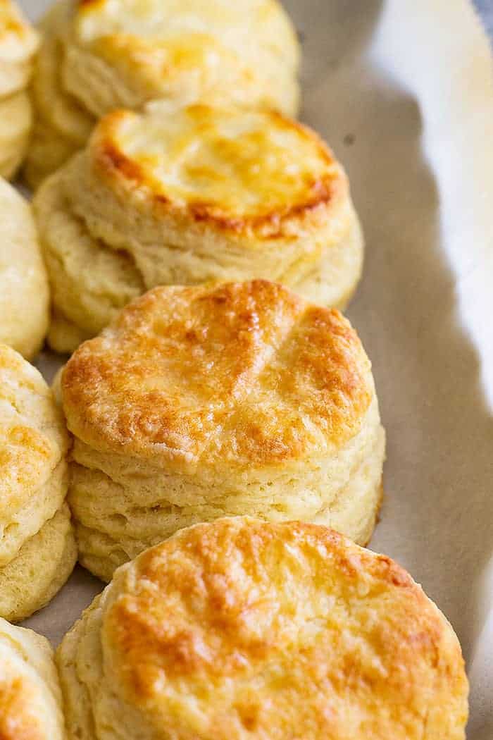 Golden, flaky buttermilk biscuits on a sheet pan.