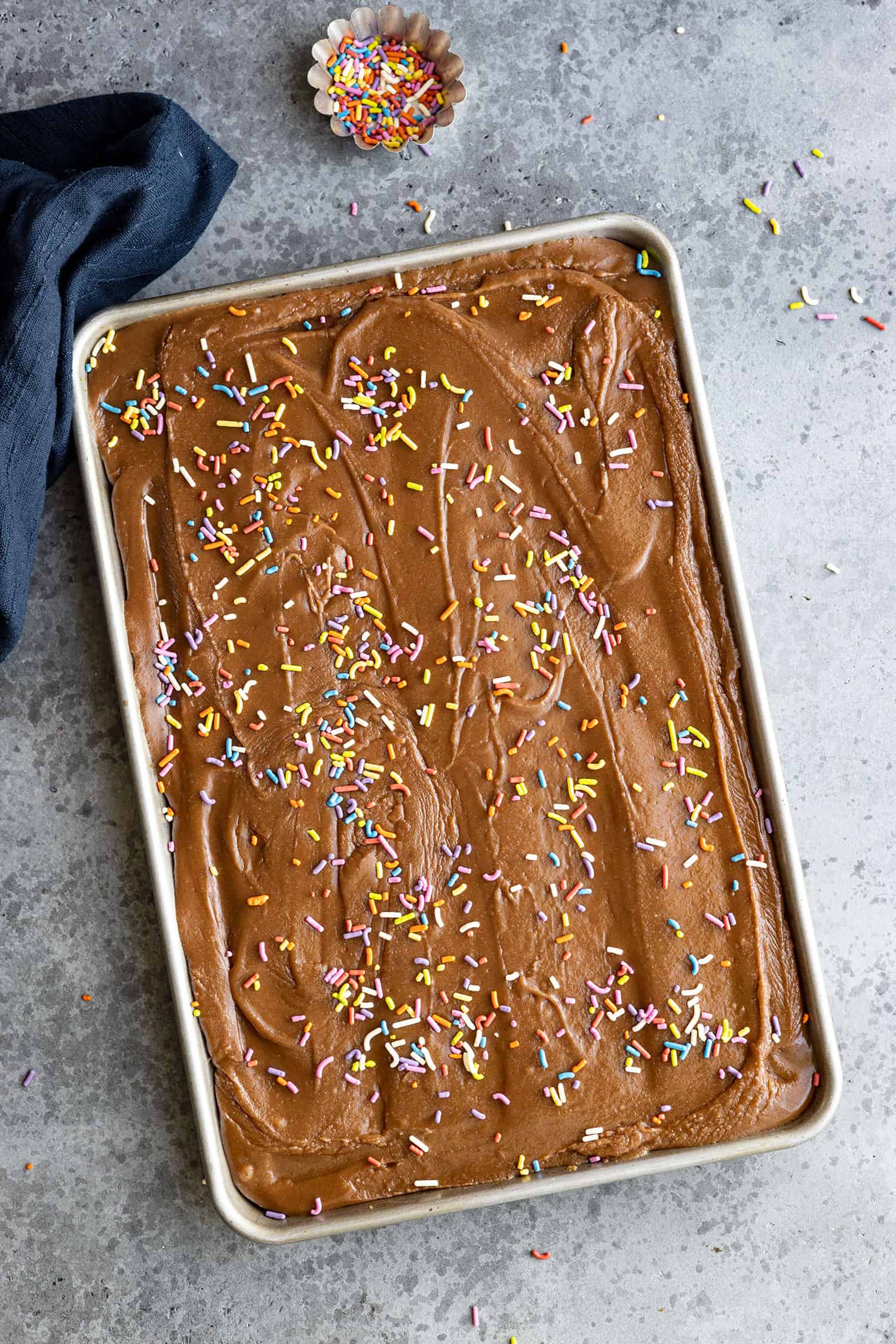 Overhead view of frosted brownies topped with colorful sprinkles. 