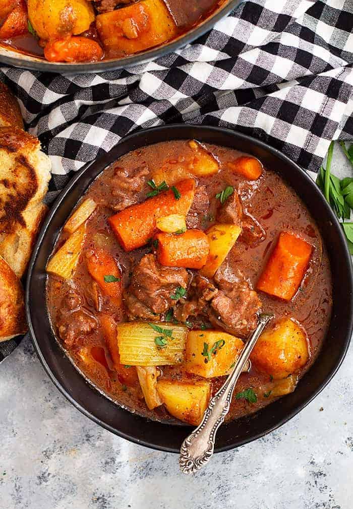 overhead: a bowl of hearty beef stew with meat and vegetables showing