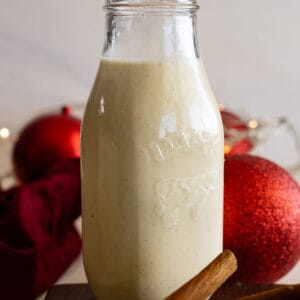 A tall jar of homemade eggnog ready to serve.