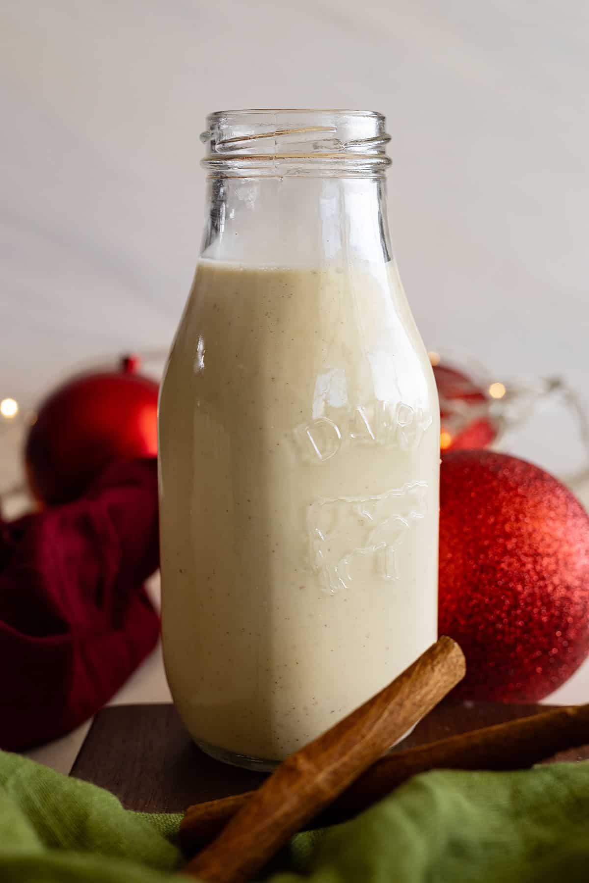 A tall jar of homemade eggnog ready to serve. 