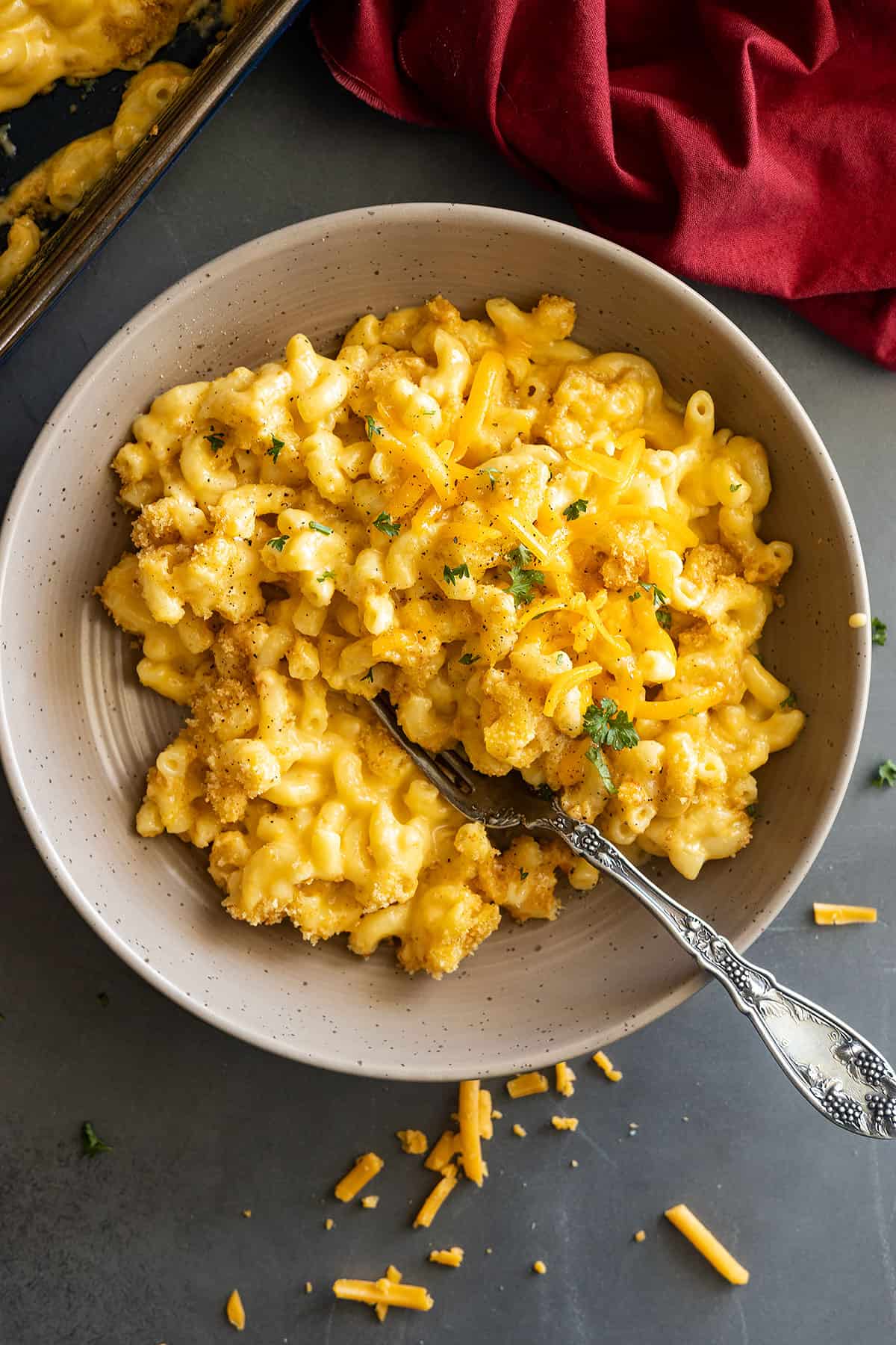 Overhead of mac and cheese in a bowl garnished with pepper and parsley. 