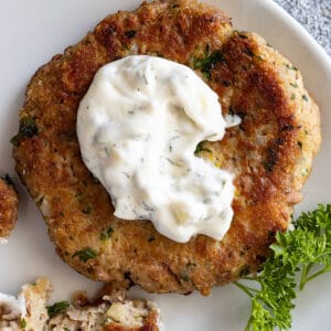Overhead view of tartar sauce on a tuna patty.
