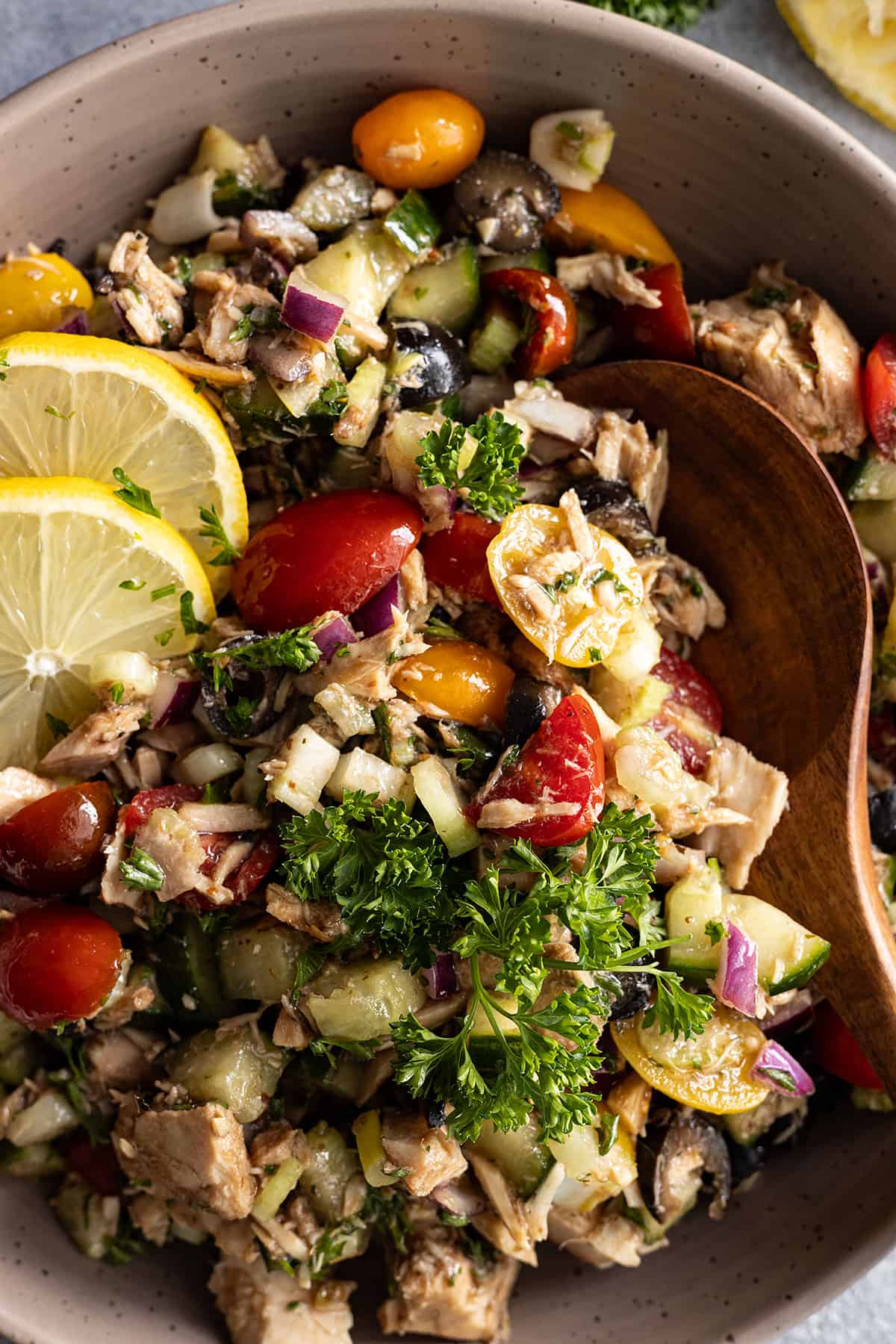 A spoon dipping into the Mediterranean tuna salad ready to serve.  