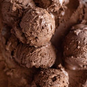 Overhead view of scoops of chocolate ice cream in a container.