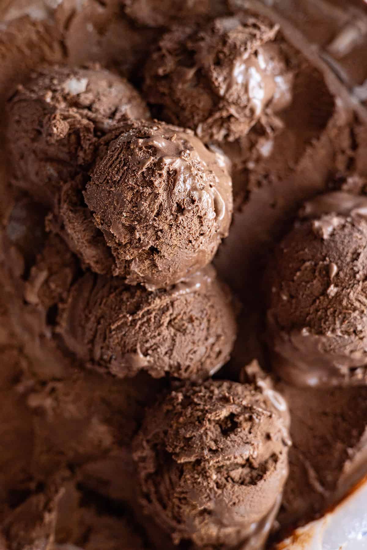 Overhead view of scoops of chocolate ice cream in a container.