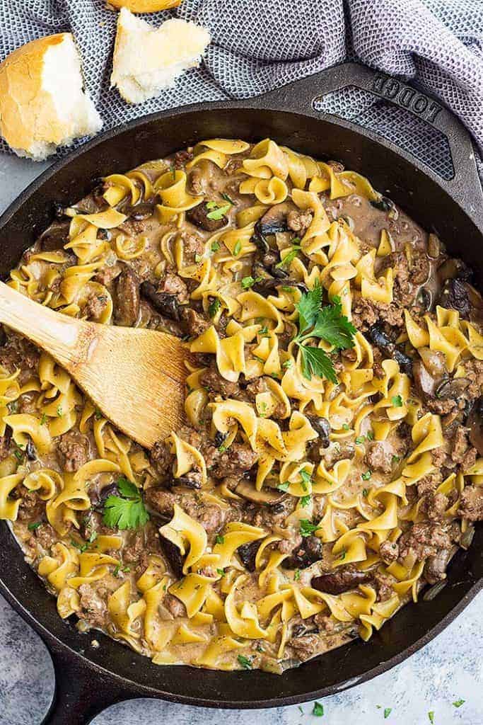 A top down view of one pot hamburger stroganoff in a pan with a spoon.