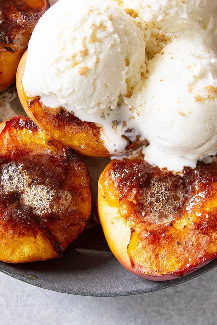 Close up of peaches on the grill and ice cream.
