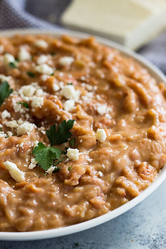 Big bowl of refried beans sprinkled with cheese. 