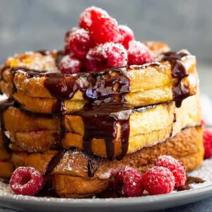 Raspberry Cheesecake Stuffed French Toast -is a very special brunch or breakfast! Buttery brioche bread stuffed with raspberry cheesecake filling then drizzled with hot fudge sauce! It's like dessert for breakfast!