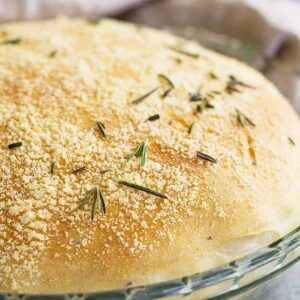 Close up of a round loaf of rosemary parmesan bread.