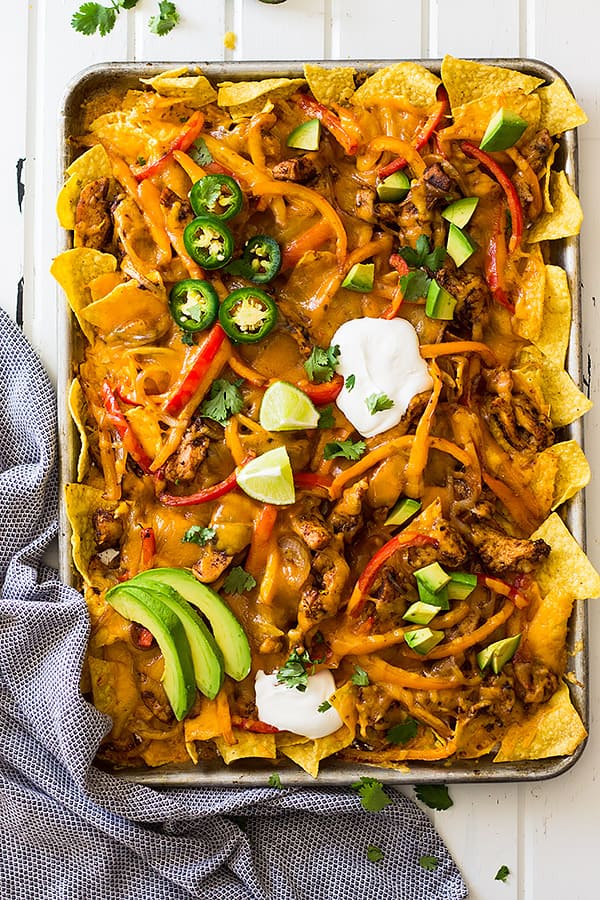 This Sheet Pan Chicken Fajita Nachos is a great game day appetizer for a crowd! Filled with seasoned chicken and vegetables and lots of cheese! | www.countrysidecravings.com