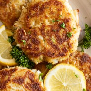 Close up of cakes on a plate garnished with fresh lemon and parsley.