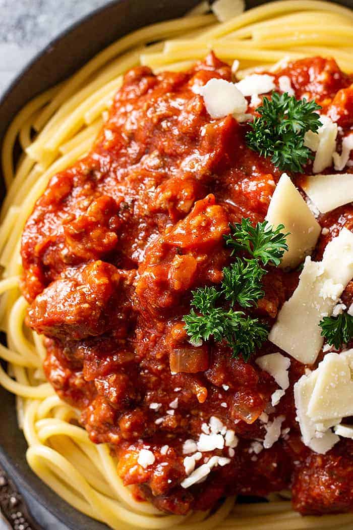 overhead closeup: slow cooker spaghetti sauce on pasta and topped with cheese