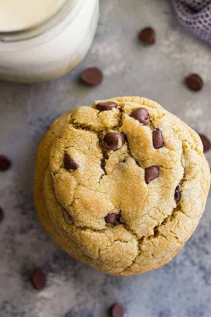 A top down view of small batch chocolate chip cookies and a glass of milk. 