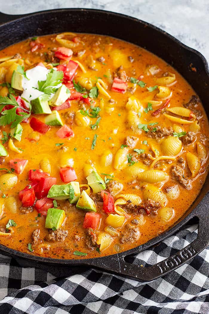Large pan of taco pasta topped with taco toppings.