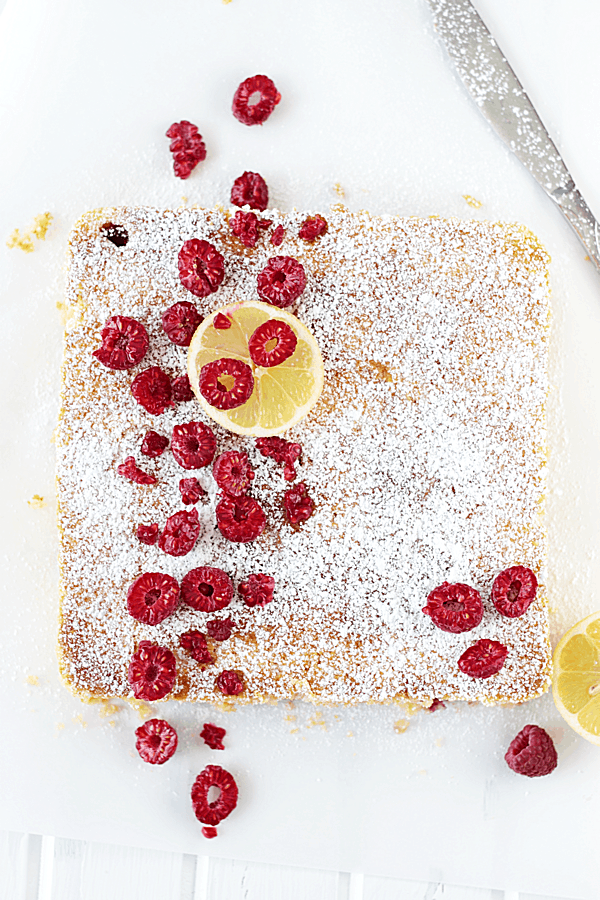 Lemon Raspberry Coffee Cake covered in powdered sugar and fresh raspberries